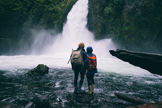 Two hikers looking at a waterfall, in a photo about to be shared on Facebook with Do Camera.